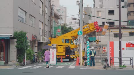 Mujer-Caminando-Por-La-Carretera-Cerrada-Debido-A-La-Construcción-En-Tokio,-Japón---Toma-Amplia