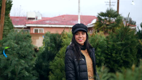 Una-Mujer-Hermosa-Con-Un-Espíritu-Navideño-Feliz-Sonriendo-Mientras-Compra-árboles-De-Navidad-Festivos-De-Abeto-Douglas