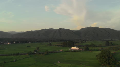 Sunset-landscape-view-countryside-farming-rice-fields-and-mountains-and-sun-goes-down-behind-mountains