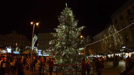 Personas-Que-Fluyen-Alrededor-De-Un-árbol-De-Navidad-En-La-Plaza-De-La-Libertad-En-El-Centro-De-Brno-Durante-Un-Evento-De-Navidad-Capturaron-Un-árbol-Durante-La-Noche-Capturado-En-Cámara-Lenta-De-4k-60fps
