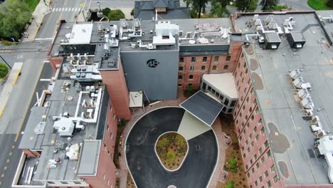 Aerial-descending-tilt-shot-of-The-Wilbur-Hotel,-drone-pull-back-reveals-renovated-brick-chocolate-factory