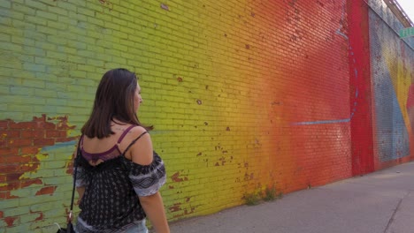 Young-girl-walking-in-front-of-a-colourful-wall-in-New-York-City