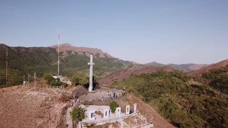 An-aerial-approaching-view-of-a-giant-catholic-cross-located-atop-mount-Tapyas-overlooking-the-town-of-Coron,-Palawan,-Philippines