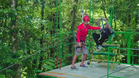 Zip-Lining-Lehrer-Hilft-Touristen-Beim-Sicheren-Seilrutschen-In-Arenal,-Costa-Rica