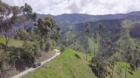 Following-a-Toyota-4runner-on-a-beautiful-mountain-road-through-the-worlds-tallest-wax-palm-trees-in-the-Cocora-Valley,-Colombia