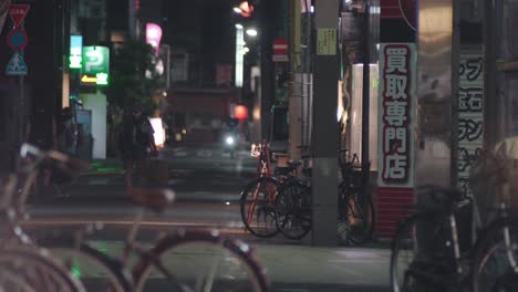 Japoneses-Caminando-Y-Andando-En-Bicicleta-Por-La-Noche-En-La-Calle-De-Kamata-En-Tokio,-Japón