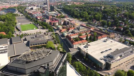 Drone-shot-at-glass-fronted-with-reflections-buildings-next-to-Liseberg-amusement,-Göteborg