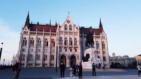 Vorderansicht-Des-Budapester-Parlaments-Mit-Touristen,-Die-Die-Aussicht-Bewundern
