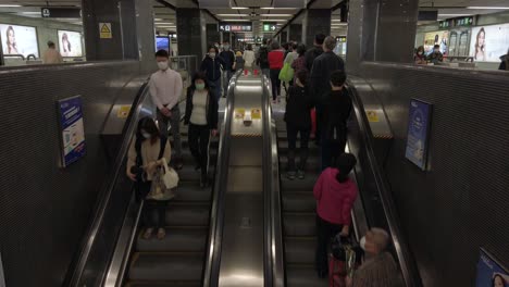 Corona-Virus-Pandemie,-Lokale-Pendler,-Die-Eine-U-Bahn-Rolltreppe-In-Hongkong-Benutzen,-Tragen-Schützende-Gesichtsmasken