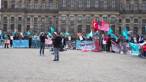 Panning-shot-of-a-East-Turkestan-demonstration-against-the-Chinese-cultural-genocide-of-Uyghurs,-in-the-middle-of-Dam-Square-in-Amsterdam