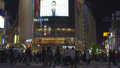 Massen-Von-Fußgängern,-Die-Nachts-über-Den-Shibuya-Kreuzung-Laufen