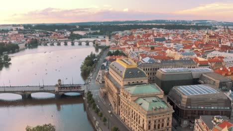 Aerial-drone-View-Of-Prague-Narodni-Divadlo,-National-Theatre-over-The-River-Vltava-at-sunset,-classical-opera-monumental-architecture