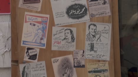 Una-Novedad-De-Moda-Cafetería-Y-Tienda-En-Al-Qaysariya-Souq-En-Muharraq,-Bahrein-Con-Viejos-Anuncios-De-Periódicos-Pegados-En-Sus-Puertas