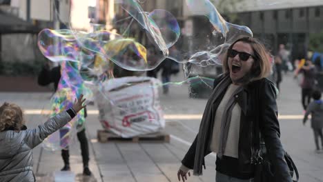 Slomo-of-soap-bubbles-in-air-by-woman-and-small-girl-in-Barcelona