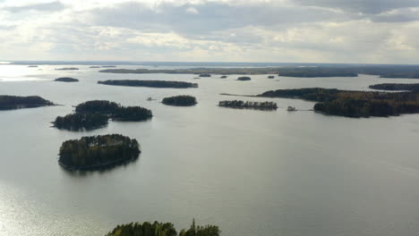 Aerial,-tracking,-drone-shot,-panning-over-islands,-in-the-archipelago-of-Porvoo,-on-the-Gulf-of-Finland,-mostly-cloudy-day,-in-Uusimaa,-Finland