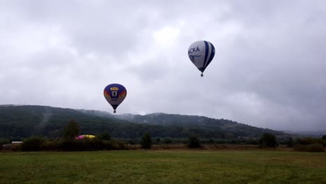 Globos-Aerostáticos-Que-Se-Lanzan-Al-Cielo-De-Una-Mañana-Nublada-Durante-Un-Evento-En-Campu-Cetatii,-Rumania