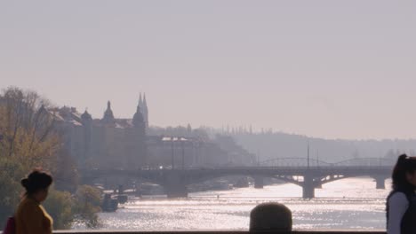 Personas-Cruzando-El-Puente-En-Praga-Con-Vysehrad-En-El-Backrround