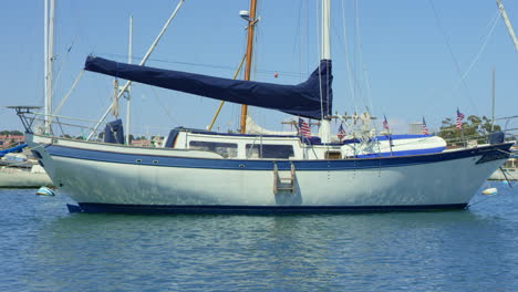 Weißes-Und-Blaues-Luxus-Segelboot-In-Zeitlupe-Am-Hafen-Mit-US-Flaggen