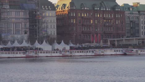 Wide-panning-view-of-the-Christmas-market-near-sunset-at-Binnenalster-in-Hamburg,-Germany,-in-Dec-2019