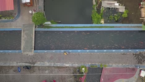 Aerial-view,-slum-river-flow-becomes-clean-and-there-are-fish-in-Lepen-Dam
