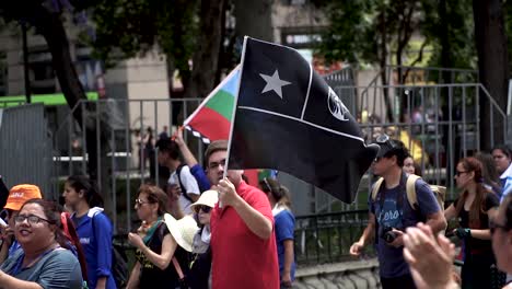 Zeitlupe-Eines-Chilenischen-Mannes-Mitten-In-Der-Menge,-Der-Während-Des-Protests-In-Santiago,-Chile,-Eine-Schwarze-Flagge-Trägt