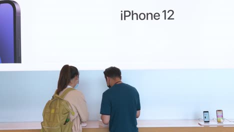 Un-Cliente-Asistido-Por-Un-Empleado-De-Apple,-Ya-Que-La-Marca-De-Tecnología-Estadounidense-Ha-Lanzado-Sus-Nuevos-Teléfonos-Inteligentes-IPhone-12-Y-IPhone-12-Pro-En-Hong-Kong