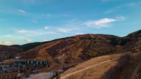 Aerial-hyperlapse-and-cloudscape-over-a-ski-resort-and-mountain-community-in-autumn