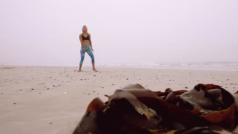 A-woman-doing-leg-stretches-at-the-beach
