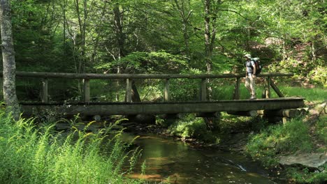 One-man-crosses-a-footbridge-at-Judy-Springs,-within-the-Spruce-Knob-Seneca-Rocks-National-Recreation-Area-in-West-Virginia