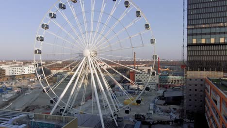 Aerial-View-of-Hi-Sky-Ferris-Wheel,-Big-Transportable-Landmark-of-Munich-Germany-on-Summer-Evening,-Descending-Drone-Shot