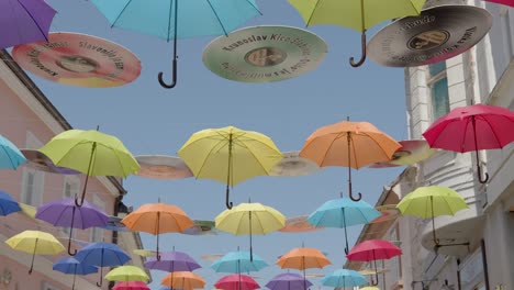 Colorful-umbrellas-sway-gently-above-the-street-in-Pozega,-Croatia,-Umbrella-Sky-project