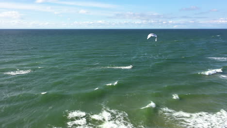 AERIAL:-Pan-Tracking-Shot-of-Surfer-Kiting-With-Power-Kite-on-Baltic-Sea
