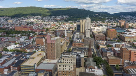 City-of-Reading-Pennsylvania,-aerial-hyperlapse-timelapse-truck-shot-of-large-urban-American-city-during-summer,-shadows-from-clouds,-metropolitan-theme