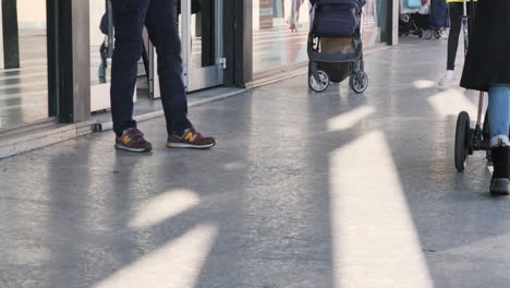 Cropped-View-Of-People-Walking-In-And-Out-Of-A-Shop-On-A-Weekend-In-Monza,-Northern-Italy-During-Winter