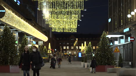 Slow-motion:-downtown-during-Christmas-period,-people-walking-and-decorations