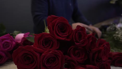Caucasian-florist-with-mask-making-and-selling-red-and-pink-roses-bouquet-for-valentine's-day-for-delivery