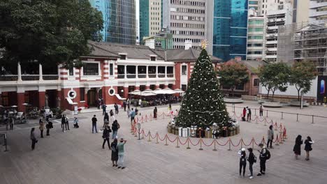 Zeitraffer-Von-Menschen,-Die-Einen-Großen-Weihnachtsbaum-In-Hongkong-Auf-Dem-Ehemaligen-Gelände-Der-Zentralen-Polizeistation-Mit-Vorbeigehenden-Menschen-Betrachten