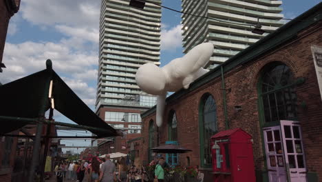 A-wide-tilt-down-from-high-rises-and-inflatable-white-figure-to-reveal-Distillery-promenade
