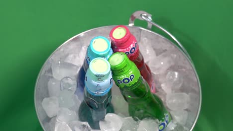 Pop-Marble-glass-bottled-Raver-drinks-bucket-of-ice-rotating-with-a-green-screen-fx-for-a-refreshing-ball-of-flavor-that-quenches-the-sensations-for-every-amazing-party-experience-of-fun-celebrations