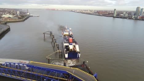 Stena-Line-logistics-ship-departs-from-terminal-aerial-view-Birkenhead-Liverpool-harbour-city-landscape-high-orbit-left