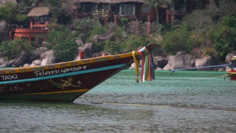 Bunte-Bänder-Segnen-Das-Thailändische-Longtail-Wassertaxi,-Das-Am-Strand-Festgemacht-Ist