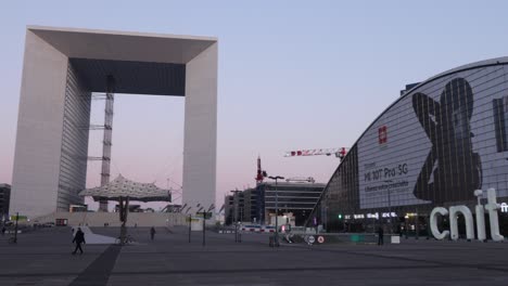 La-Defense-Plaza-Am-Frühen-Morgen-Mit-Wenigen-Menschen,-Dem-Großen-Bogen-Und-Dem-Cnit