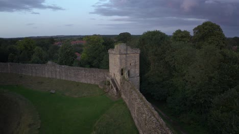 Aerial-closeup-shot-of-the-partly-ruined-curtain-wall-surrounding-Pickering-Castle