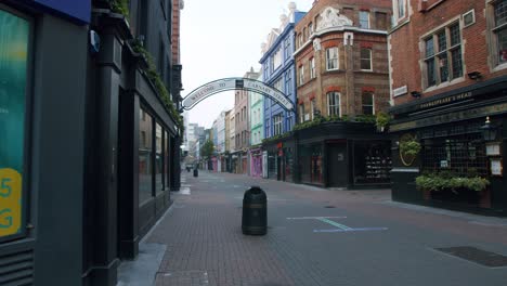 Lockdown-in-London,-cinematic-reveal-of-Carnaby-Street's-entrance-sign-with-social-distancing-signage-on-the-empty-streets,-during-the-Coronavirus-pandemic-2020