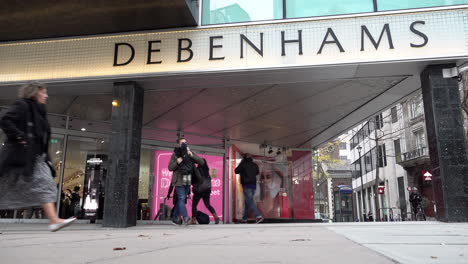 Shoppers-enter-and-exit-Debenhams-department-store-as-people-stroll-along-Oxford-Street-on-the-first-morning-a-new-Covid-regulation-three-tier-system-allowed-non-essential-businesses-to-open