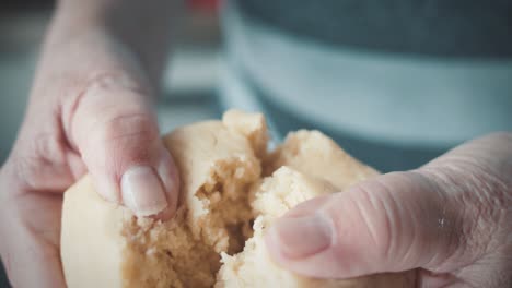 Hands-of-an-elderly-person-cut-fresh,-moist-cake-batter