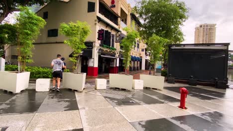 Men-Jogging-By-The-Closed-Bars-Beside-Singapore-River-During-Pandemic---Wide-Shot