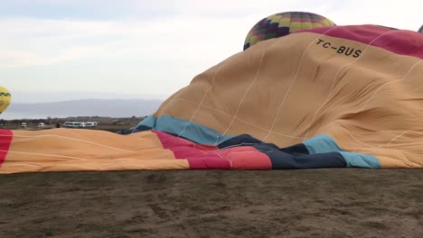 People-preparing-hot-air-balloon-with-hot-air,-close-up-pan-right-view