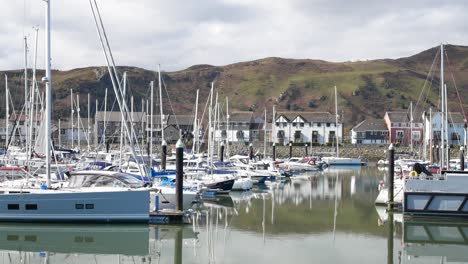 Yachts-and-sailboats-moored-under-luxury-Conwy-mountainous-marina-waterfront-North-Wales