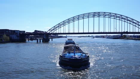 Merchant-Vessel-Crossing-At-River-Noord-With-Arch-Bridge-Behind-Near-Hendrik-Ido-Ambacht,-Netherlands